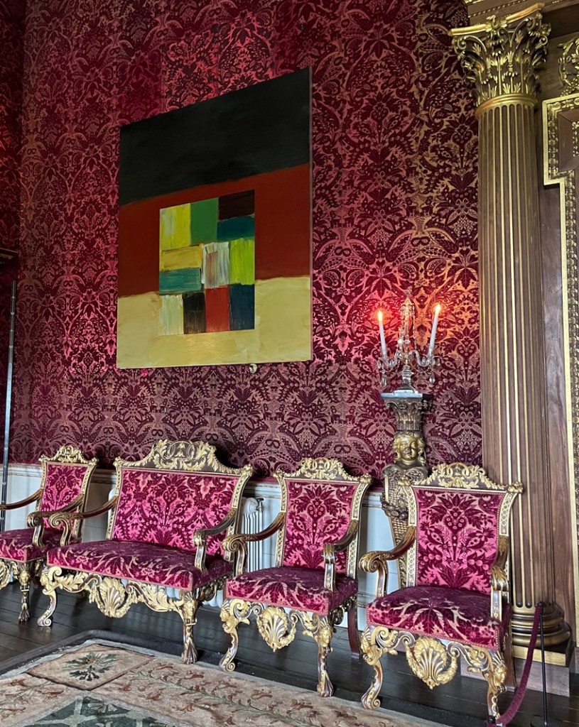 Wall Landline High Atlas by Sean Scully on display against a flock patterned crimson wall at Houghton hall above ornate gold chairs